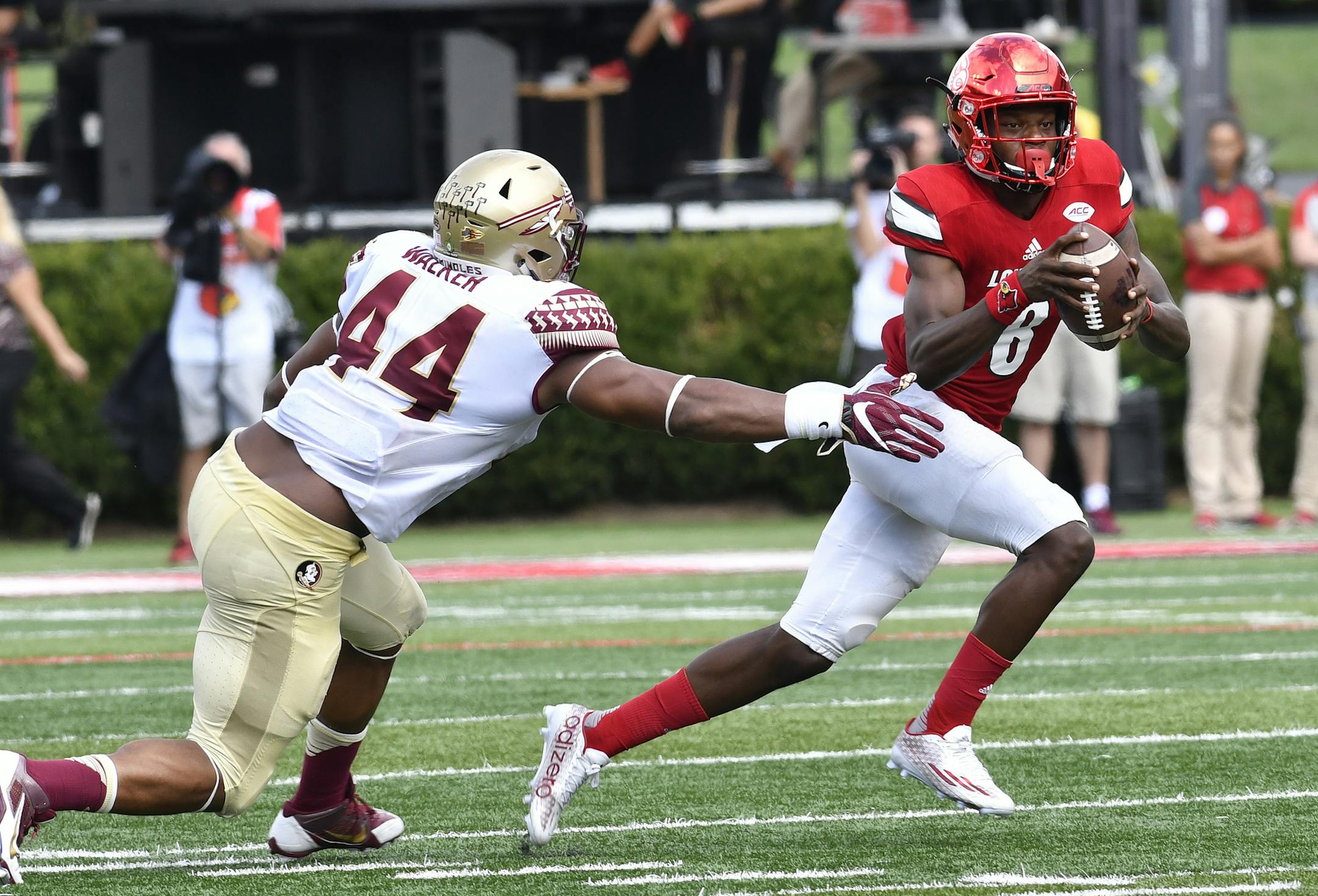 Louisville quarterback Lamar Jackson (8) avoids the tackle form Florida State defensive end DeMarcus Walker (44) during the third quarter of an NCAA college football game, Saturday, Sep. 17, 2016 in Louisville Ky.Louisville won 63-20. (AP Photo/Timothy D. Easley)