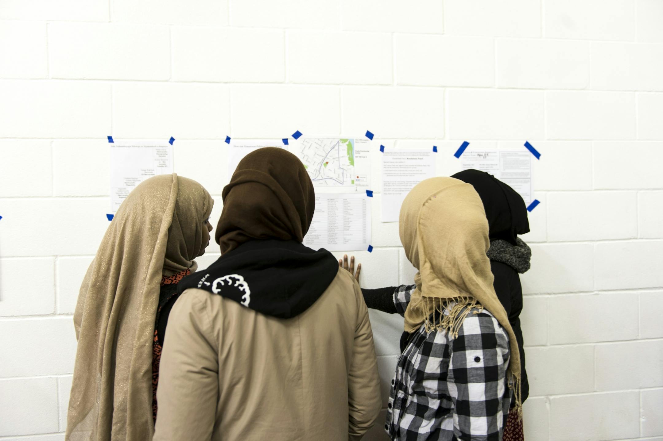 Caucus goers read the rules for delegate registration before the start of Tuesday night's caucus at the Brian Coyle Center in Minneapolis.