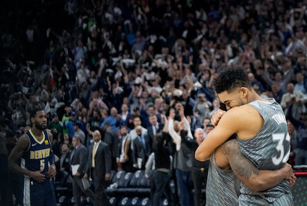 Karl-Anthony Towns, right, and Jeff Teague celebrate after the team's win over Denver