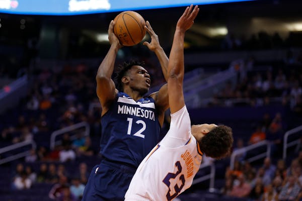 Minnesota Timberwolves guard Treveon Graham (12) shoots over Phoenix Suns forward Cameron Johnson in the first half during a preseason NBA basketball 