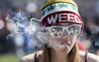 A woman exhales while smoking marijuana during the annual 420 marijuana rally on Parliament Hill in Ottawa, Canada, Wednesday, April 20, 2016. Cannabi