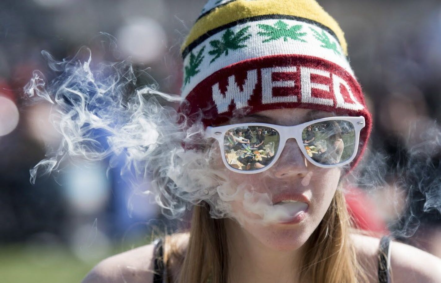 A woman exhales while smoking marijuana during the annual 420 marijuana rally on Parliament Hill in Ottawa, Canada, Wednesday, April 20, 2016. Cannabis possession is illegal in most countries under a 1925 treaty called the International Opium Convention. But just like the U.S., some nations either flout the treaty or don't enforce it. Legalization supporters consider pot possession either legal or tolerated in Argentina, Bangladesh, Cambodia, Canada, Chile, Colombia, the Czech Republic, India, J