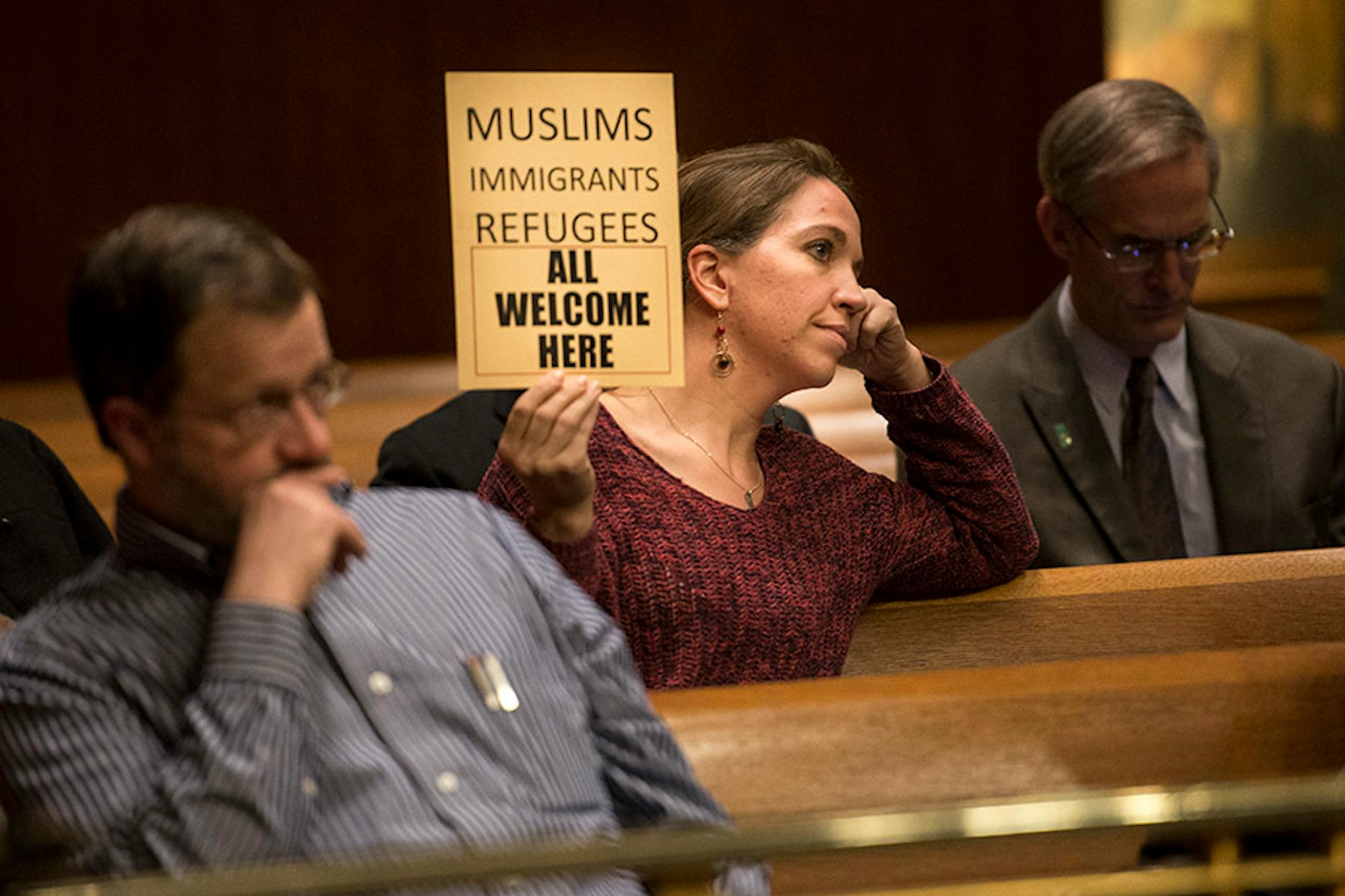 Sarah Lechowich, of St. Paul, held a sign voicing her support for a city council resolution condemning Republican presidential candidate Donald Trump for anti-Muslim, anti-refugee and anti-immigrant speech Wednesday night.