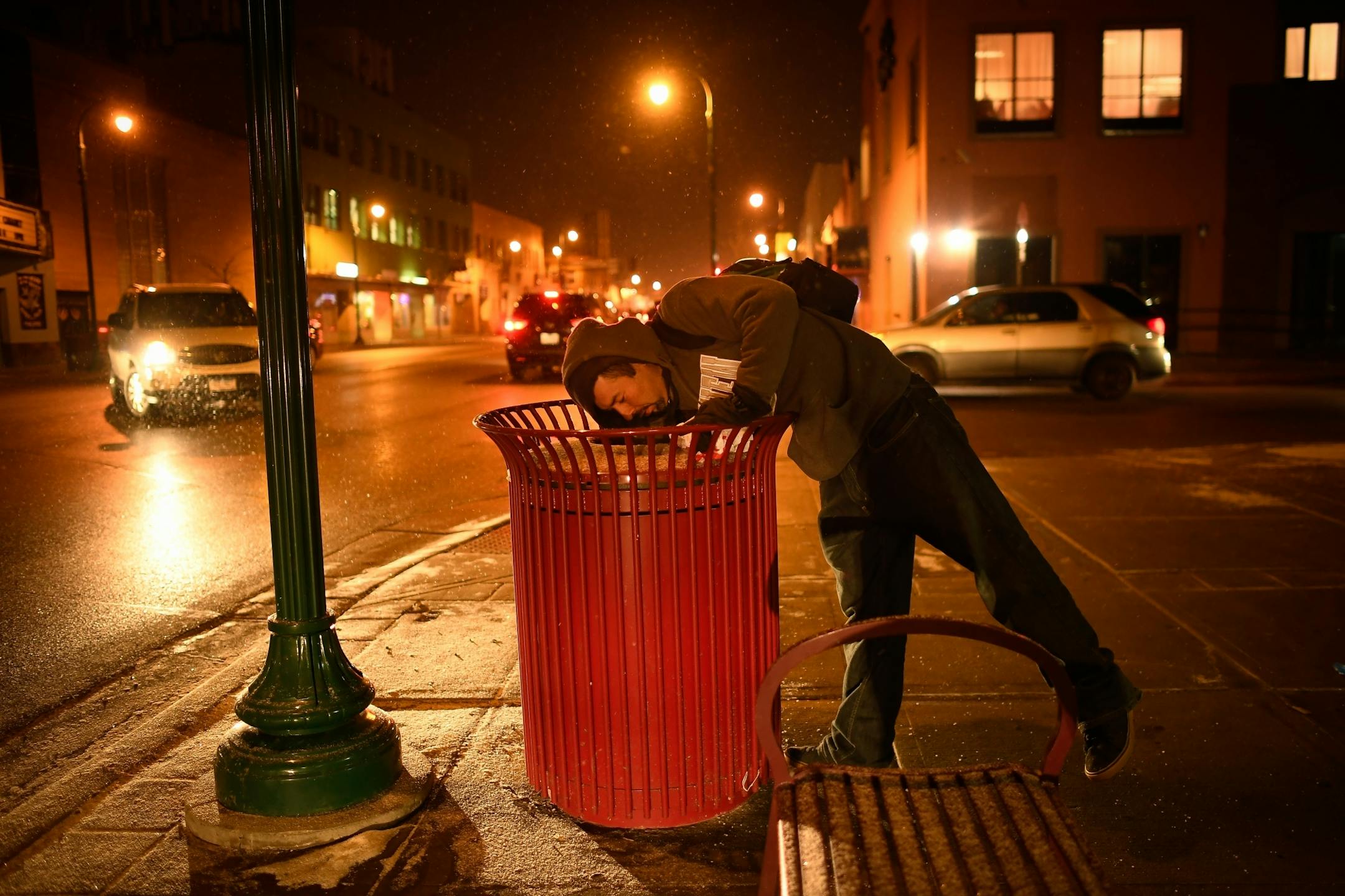 Dante Maldonado, a migrant from Guadalajara City, Mexico, reached into a trash can in search of food on East Lake Street Friday night. Maldonado has been living on the streets for six years, and is an alcoholic. "If they catch me opening a bottle, they send you to detox or a hospital or jail," said Maldonado.