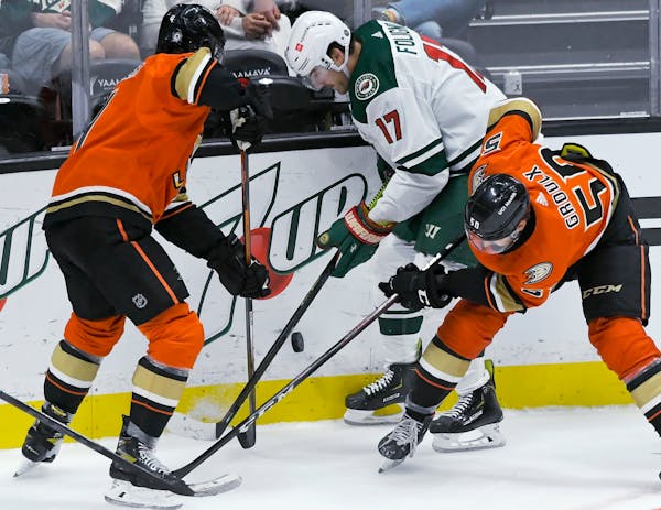 Anaheim defenseman Cam Fowler (4) and center Benoit-Olivier Groulx (50) vie for the puck with Wild left wing Marcus Foligno