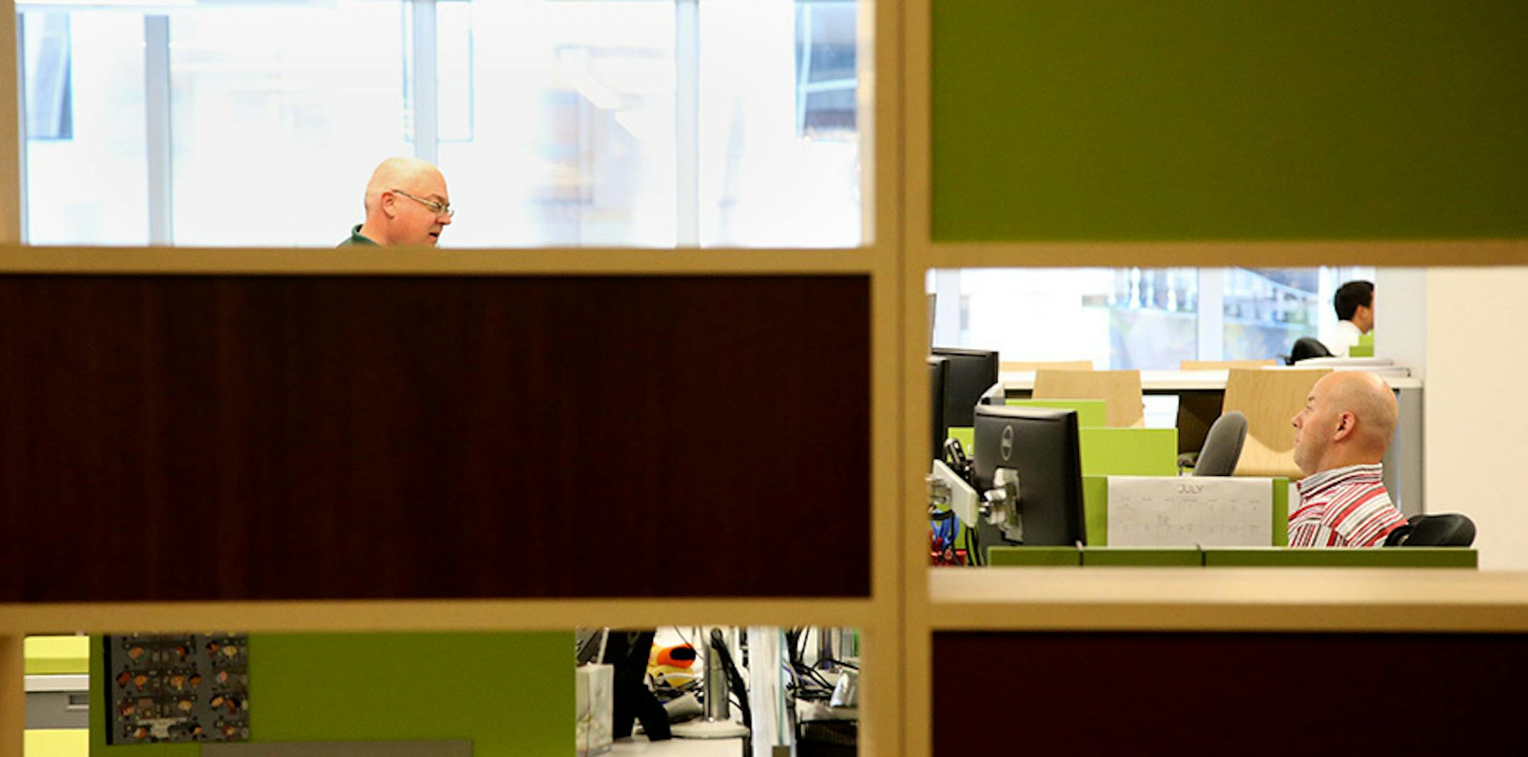 Kurt Canada, left and Devon Weide talked with each other over their desks on the newly redesigned fourth floor.