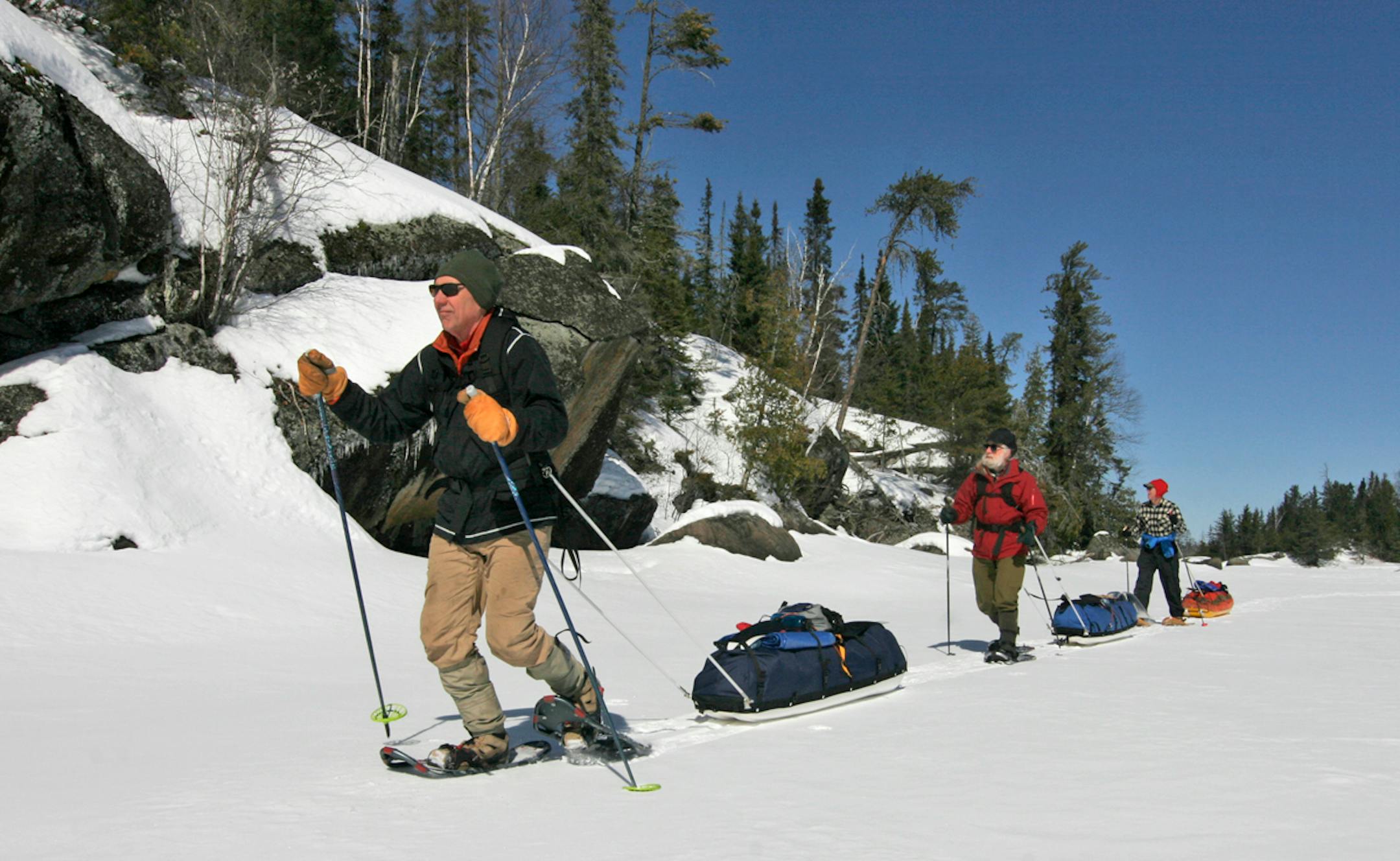 Pulling sleds loaded with caming gear, Steve Piragis, Gary Thornbloom and Sam Cook snowshoe across a frozen Boundary Waters Canoe Area Wilderness lake last weekend. Sub-zero temperatures at night froze slush and soft snow atop the lakes, making travel easier. Photo by Doug Smith/Star Tribune