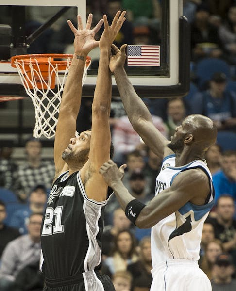San Antonio Spurs center Tim Duncan (21) and Minnesota Timberwolves forward Kevin Garnett (21) went up for a layup in the first quarter Wednesday. ] (