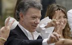 FILE - In this Sunday, Oct. 2, 2016 file photo Colombia's President Juan Manuel Santos makes the victory sign after voting in a referendum to decide w
