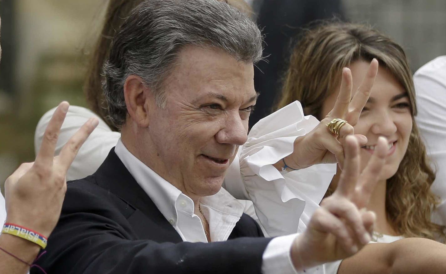 FILE - In this Sunday, Oct. 2, 2016 file photo Colombia's President Juan Manuel Santos makes the victory sign after voting in a referendum to decide whether or not to support the peace deal he signed with rebels of the Revolutionary Armed Forces of Colombia, FARC, in Bogota, Colombia. Colombian President Juan Manuel Santos has won Nobel Peace Prize it was announced on Friday Oct. 7, 2016. (AP Photo/Ricardo Mazalan, File) ORG XMIT: MIN2016100705091501