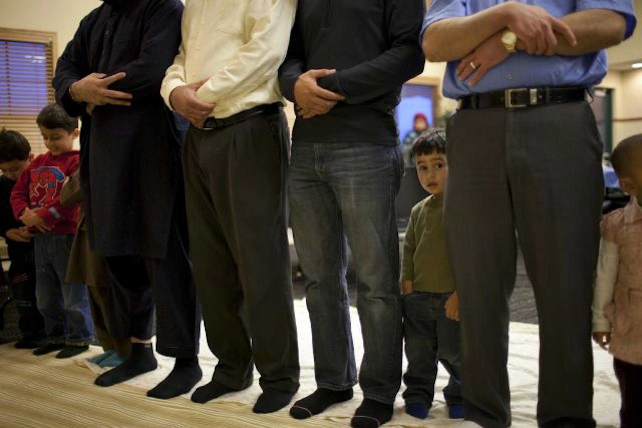 Hamza Ishtaiwi, 2, was nearly lost in a sea of much longer legs during prayers at sunset in the Northwest Islamic Community Center on Friday.
