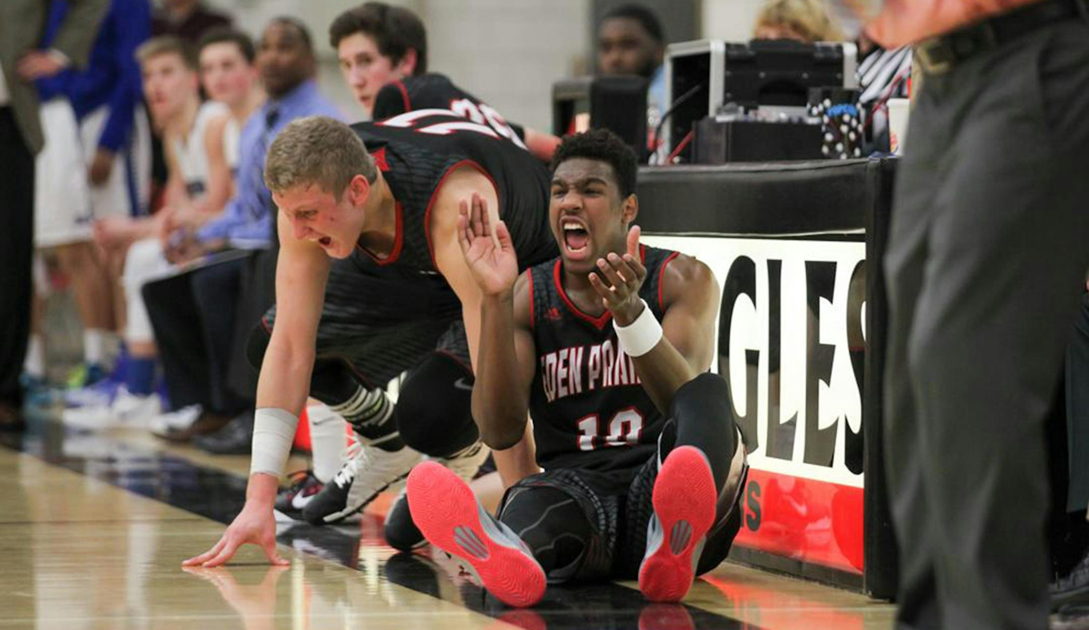 Josh Lanasa, left, and Grantham Gillard celebrate an Eden Prairie basket while waiting to check into the game Friday, Feb. 9, against Minnetonka at Eden Prairie High School. The Eagles won 92-78. Photo by Mark Hvidsten