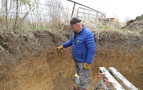 Jeff Broberg, photographed here in 2021, points to topsoil on his farm in Elba Township in southeast Minnesota.