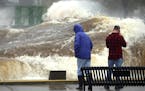 T10.10.2018 -- Steve Kuchera -- 101118.N.DNT.WavesC2 -- A large wave rolls past two spectators and down the length of the Duluth Ship Canal on Wednesd