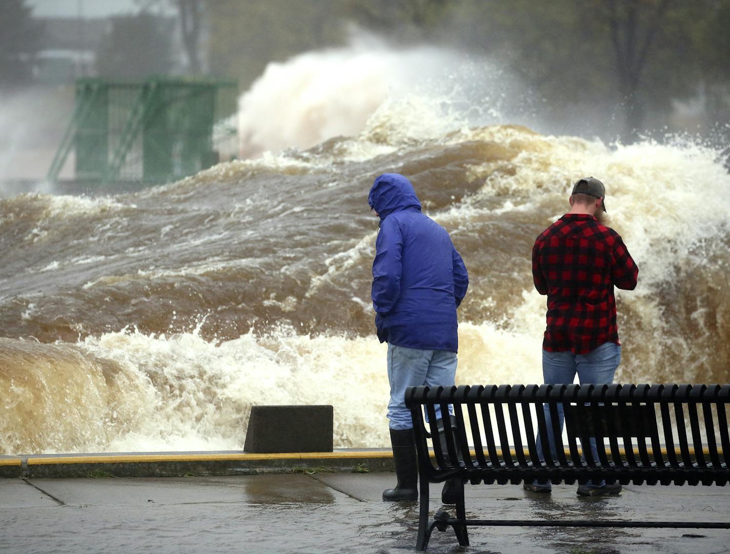 T10.10.2018 -- Steve Kuchera -- 101118.N.DNT.WavesC2 -- A large wave rolls past two spectators and down the length of the Duluth Ship Canal on Wednesday morning. Steve Kuchera / skuchera@duluthnews.com