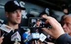 Justin Morneau is displayed on a mobile device as he talks with reporters before an interleague baseball game against Washington Nationals.