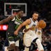 Warriors guard Stephen Curry drives while defended by Wolves guard Anthony Edwards in the second quarter Sunday night at Target Center.