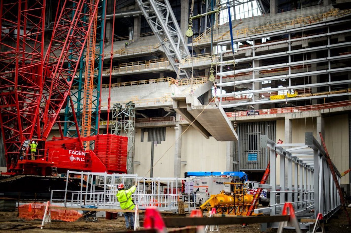 A concrete seating section panel is moved into position in the new Vikings stadium.