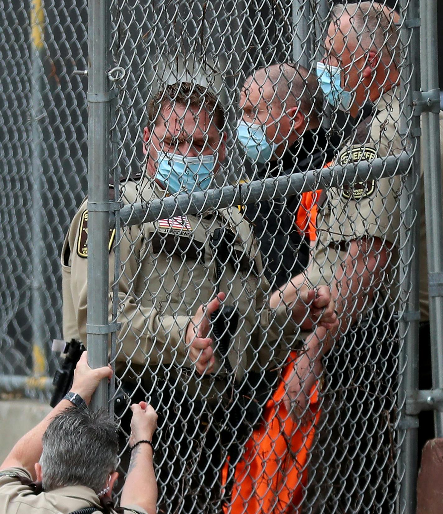 A law enforcement officer goes down while opening a gate for fired Minneapolis police officer Derek Chauvin as fellow officers escorted Chaurin from the rear of the Family Justice Center after a motion hearing Friday in Minneapolis. ] DAVID JOLES • david.joles@startribune.com Friday, Sept. 11, 2020, in Minneapolis, MN A judge will hear oral arguments Friday morning on several pending motions in the cases against four former officers in the killing of George Floyd, including motions to dismiss th