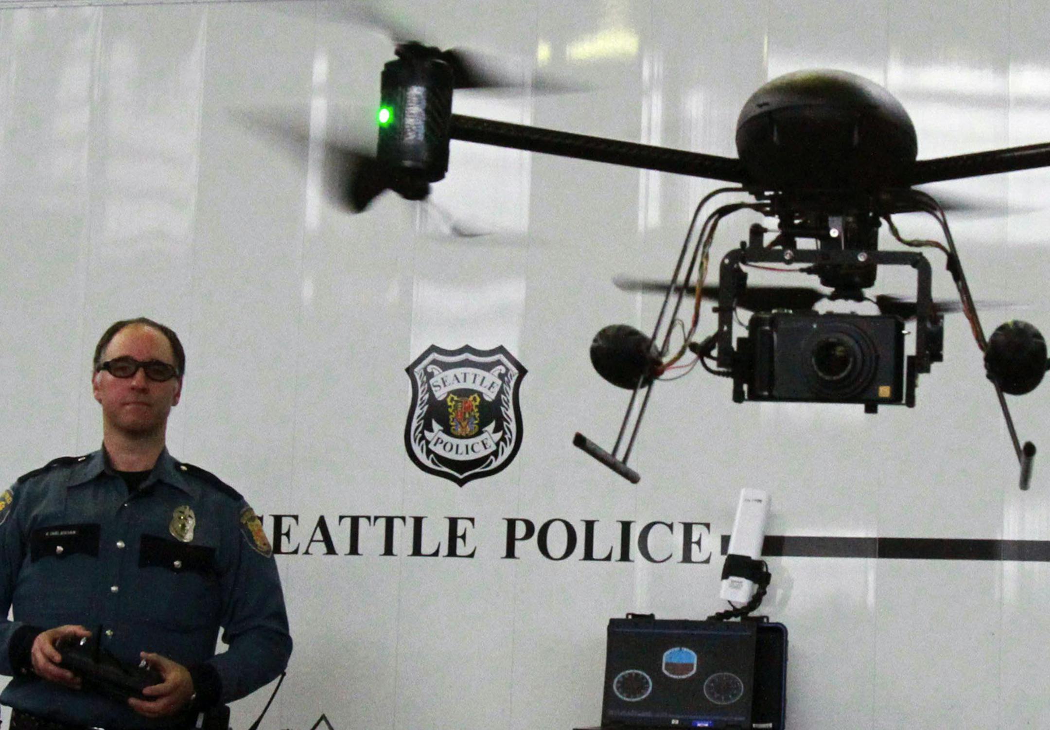 FILE - In this April 27, 2012, file photo, Seattle Police officer Reuben Omelanchuk is at the controls of the department's new, small radio-controlled Draganflyer X6 drone with a camera attached, in Seattle, Wash. The Oregon House has given final legislative approval to a bill limiting law enforcement's use of drones for surveillance. The measure passed 56-3 Wednesday, June 26, 2013, ending months of discussion about drone regulation. The bill now goes to Oregon Gov. John Kitzhaber who intends t