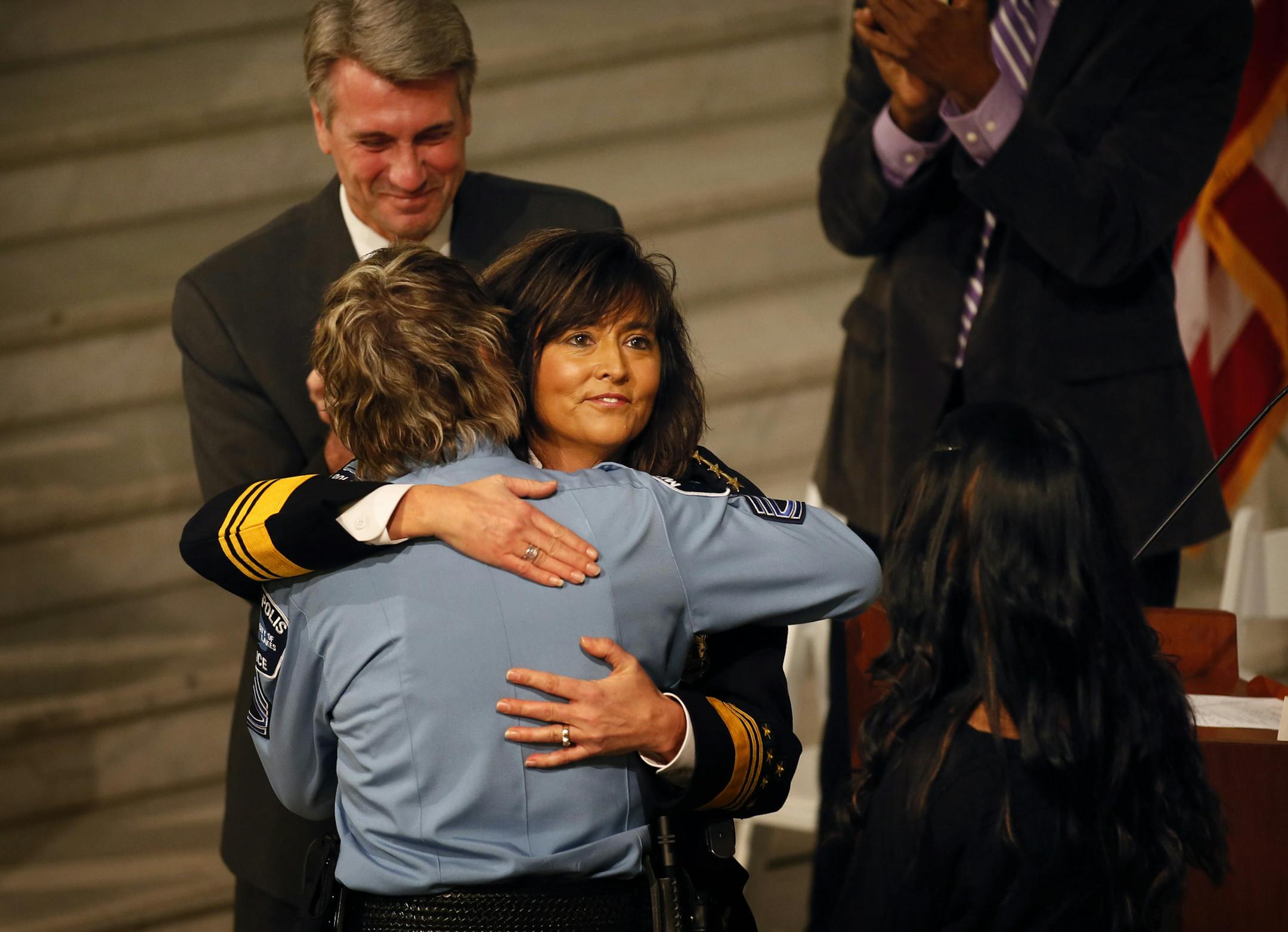 New Minneapolis Police Chief Janee Harteau was swarn in Tuesday afternoon in the City Hall Routunda. Here, Harteau gets a hug from partner Holly Keegel after her daughter Lauren Harteau (right) pined the Chief's Badge on her uniform. ] BRIAN PETERSON ‚Ä¢ brianp@startribune.com Minneapolis, MN - 12/04/2012