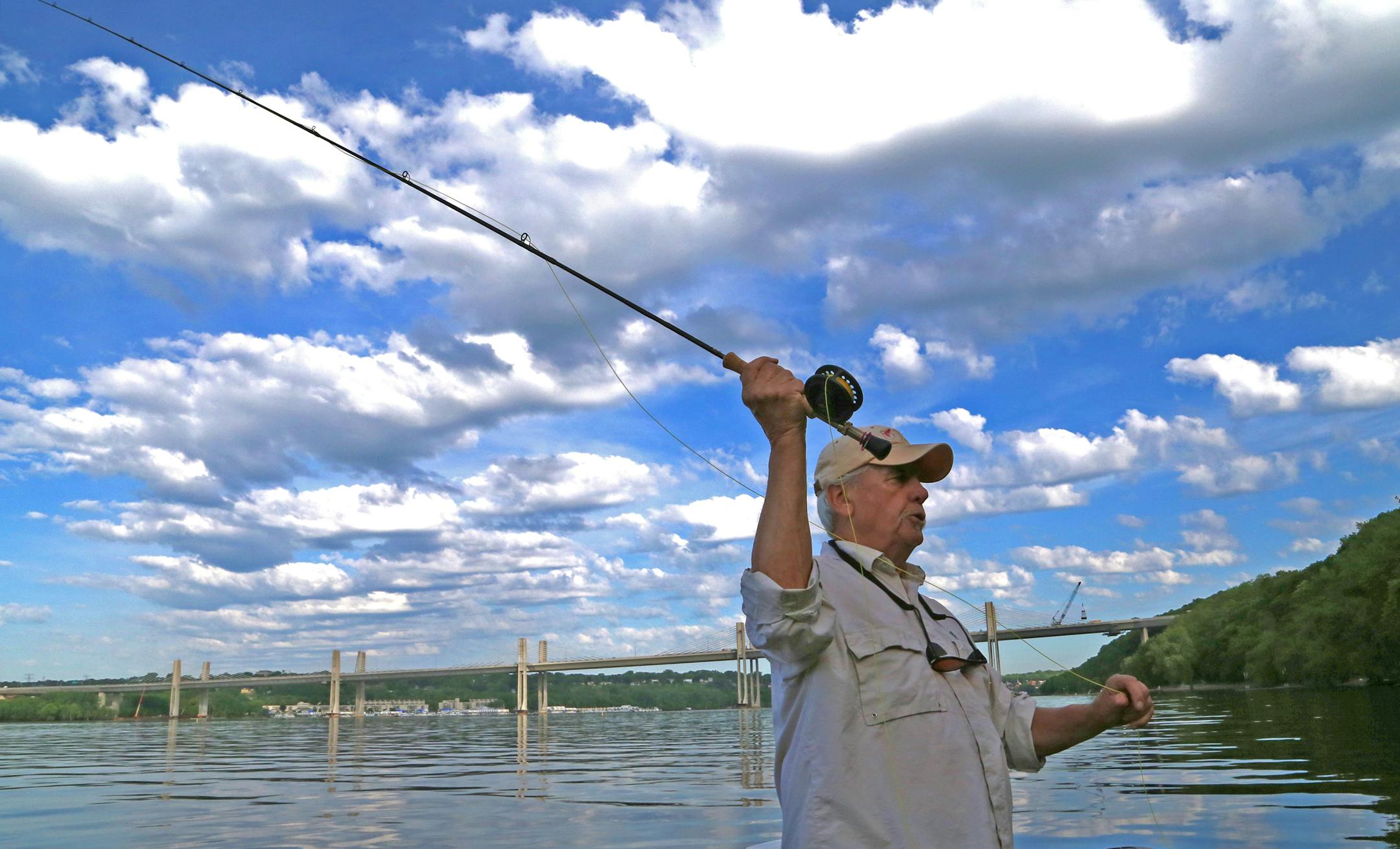 With the new St. Croix River bridge in the background, fly fisherman Bob Nasby prepared to shoot a surface bait — a “popper’’ — toward the river’s shoreline, seeking a bass, northern pike or muskie strike.