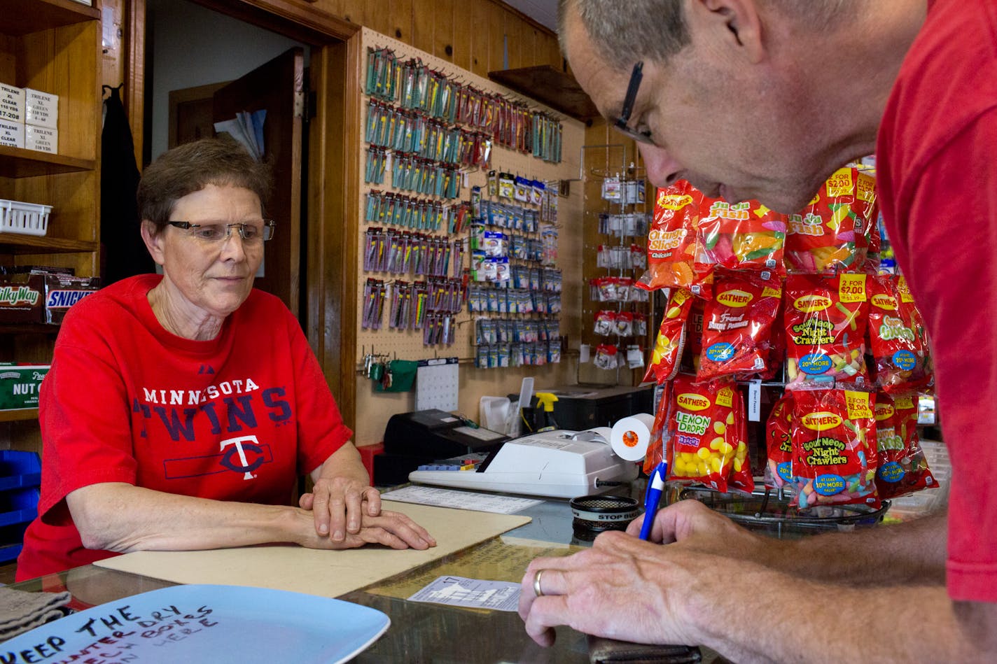 Eric Hexom signs the fishing license Joanne Rousseau provided him at Ebner's Live Bait in Elk River last July.