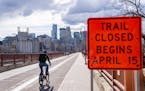 A biker rides across the Stone Arch Bridge in Minneapolis, Minn., on Thursday, April 11, 2024.