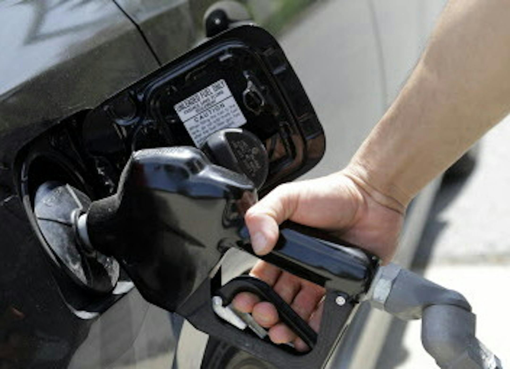 FILE - In this May 8, 2015 file photo, gas station attendant Carlos Macar pumps gas in Andover, Mass. Gasoline is close to breaking below a key psychological barrier as drivers enjoy some of the cheapest pump prices since the recession. The nationwide average price of a gallon of regular Saturday, Dec. 12, 2015 was $2.02, down 58 cents from this time last year, according to auto club AAA. Experts say it could drop below $2 in the coming days. (AP Photo/Elise Amendola, File)