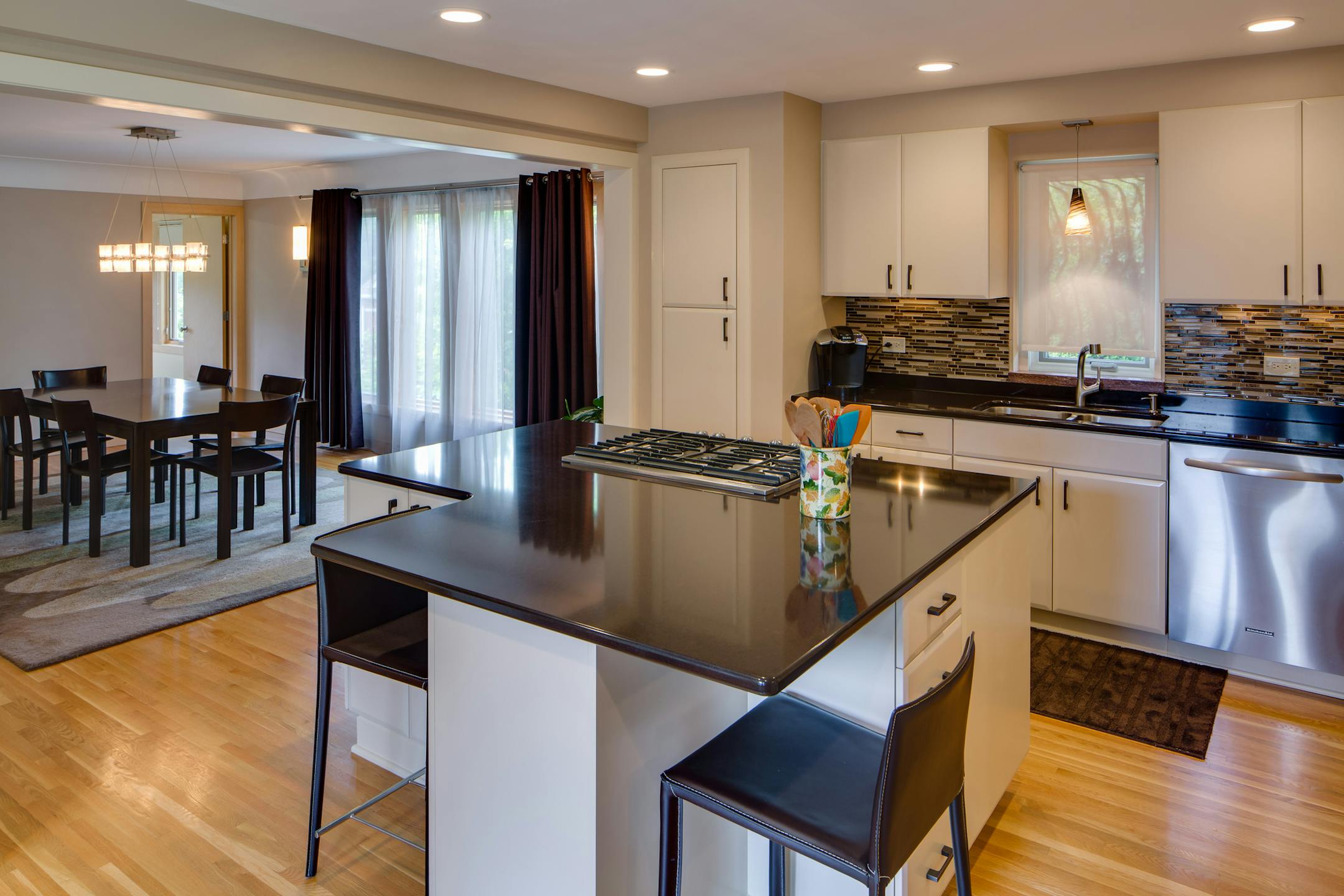 The kitchen includes a large island with a 5-burner cooktop and quartz countertops.