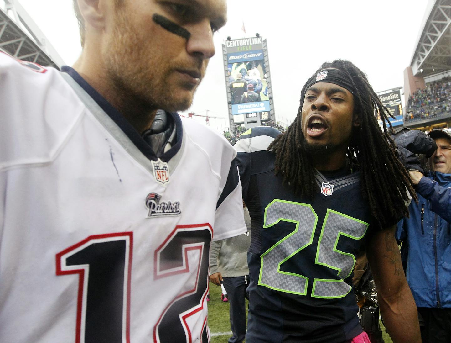 FILE - In this Oct. 14, 2014, file photo, Seattle Seahawks' Richard Sherman (25) talks with New England Patriots quarterback Tom Brady after the Seahawks won 24-23 in an NFL football game in Seattle. Sherman already gave Brady an earful the last time the Seahawks played the Patriots. This Super Bowl could feature some epic yapping from some of the best trash-talkers in the NFL. (AP Photo/Elaine Thompson)