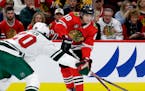 Chicago Blackhawks right wing Patrick Kane, right, looks to pass against Minnesota Wild defenseman Ryan Suter during the first period of an NHL hockey