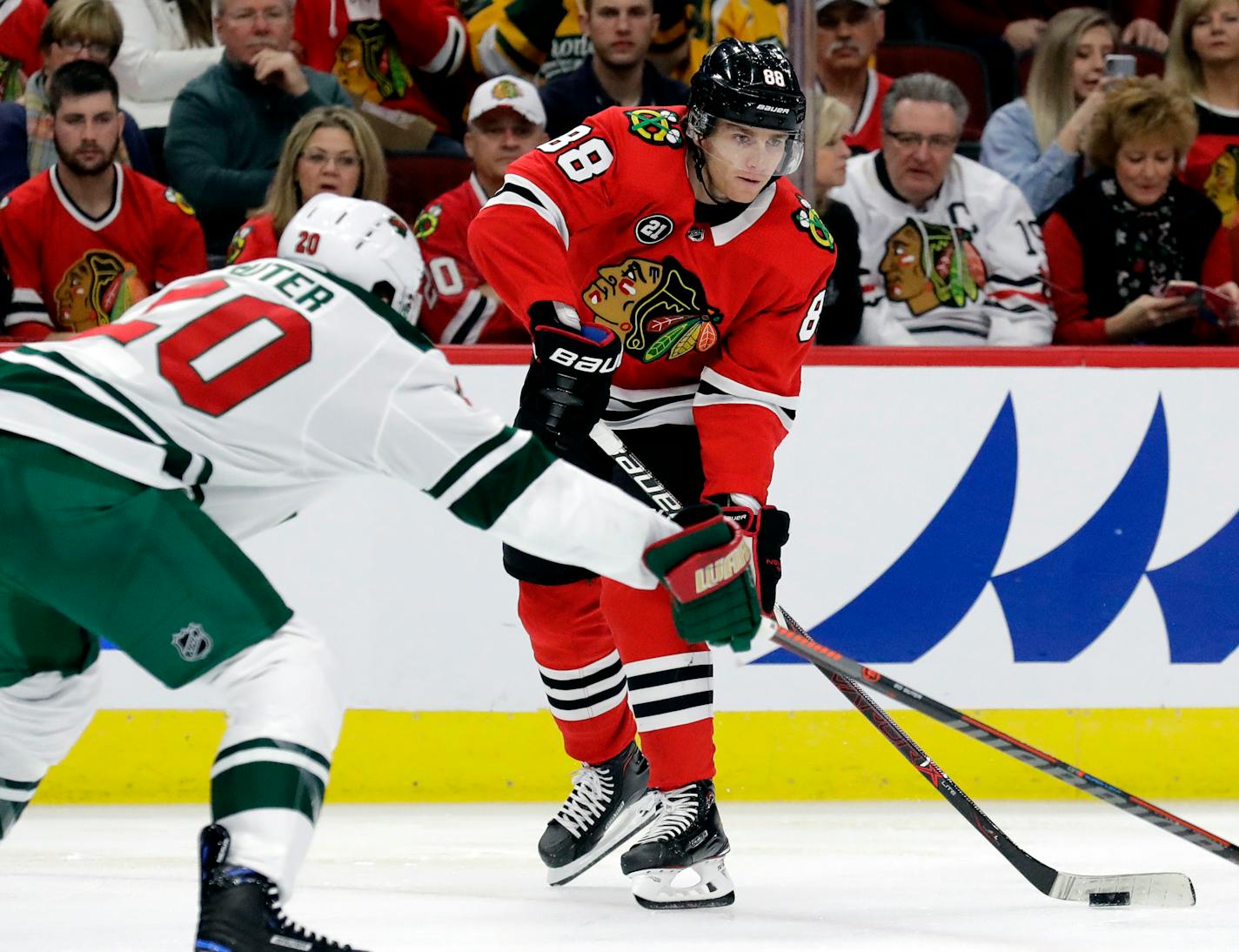 Chicago Blackhawks right wing Patrick Kane, right, looks to pass against Minnesota Wild defenseman Ryan Suter during the first period of an NHL hockey game Thursday, Dec. 27, 2018, in Chicago. (AP Photo/Nam Y. Huh)