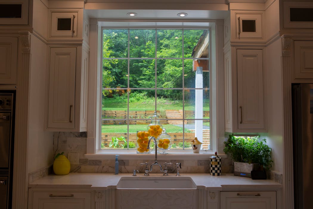 The fireclay kitchen sink features an embossed apron front and a bridge faucet. 