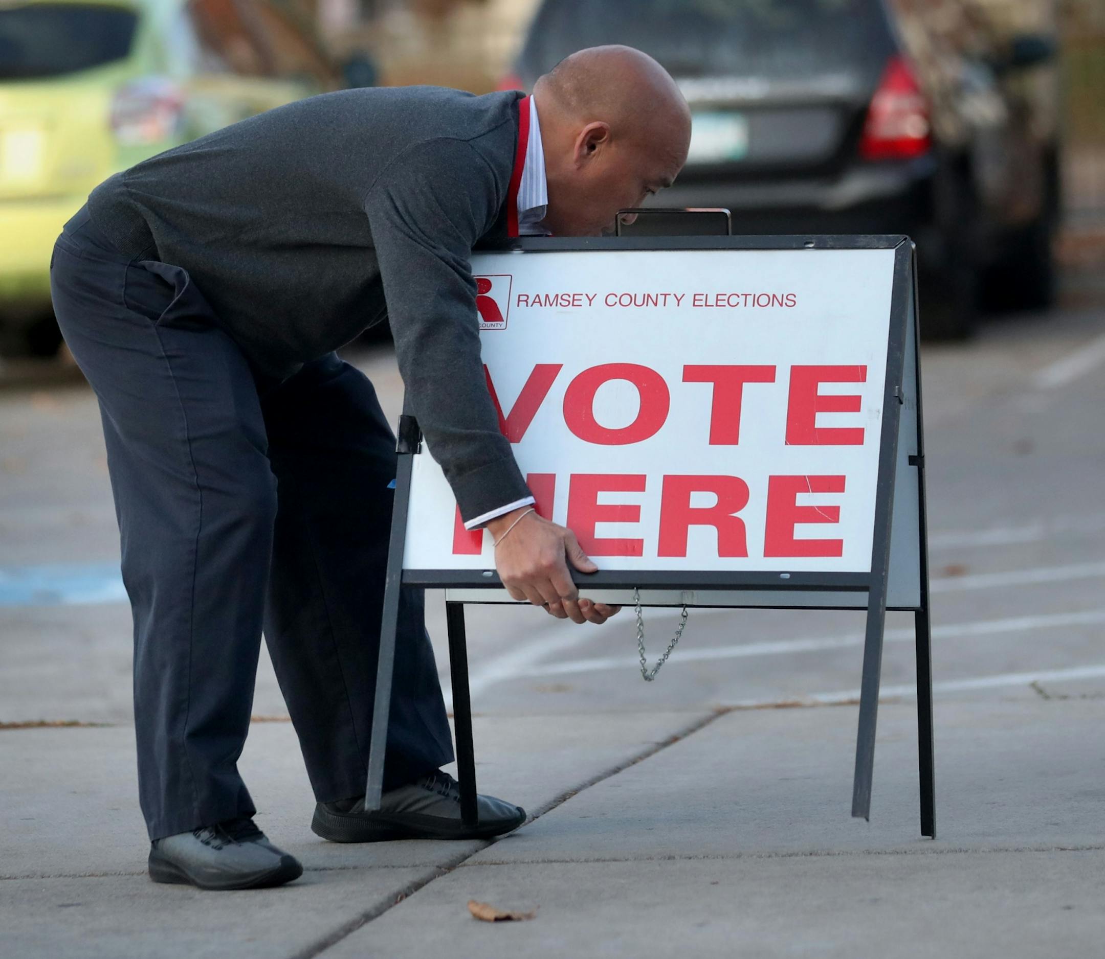 Election judge Chris Yang placed a voting sign in the parking lot at the Arlington Hills Community Center in St. Paul.
