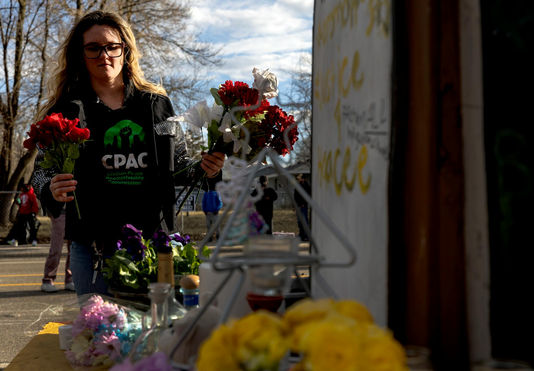 A woman places flowers on a memorial at a Vigil honoring Daunte Wright on one-year anniversary of his death Monday, April 11, in Brooklyn Center, Minn.