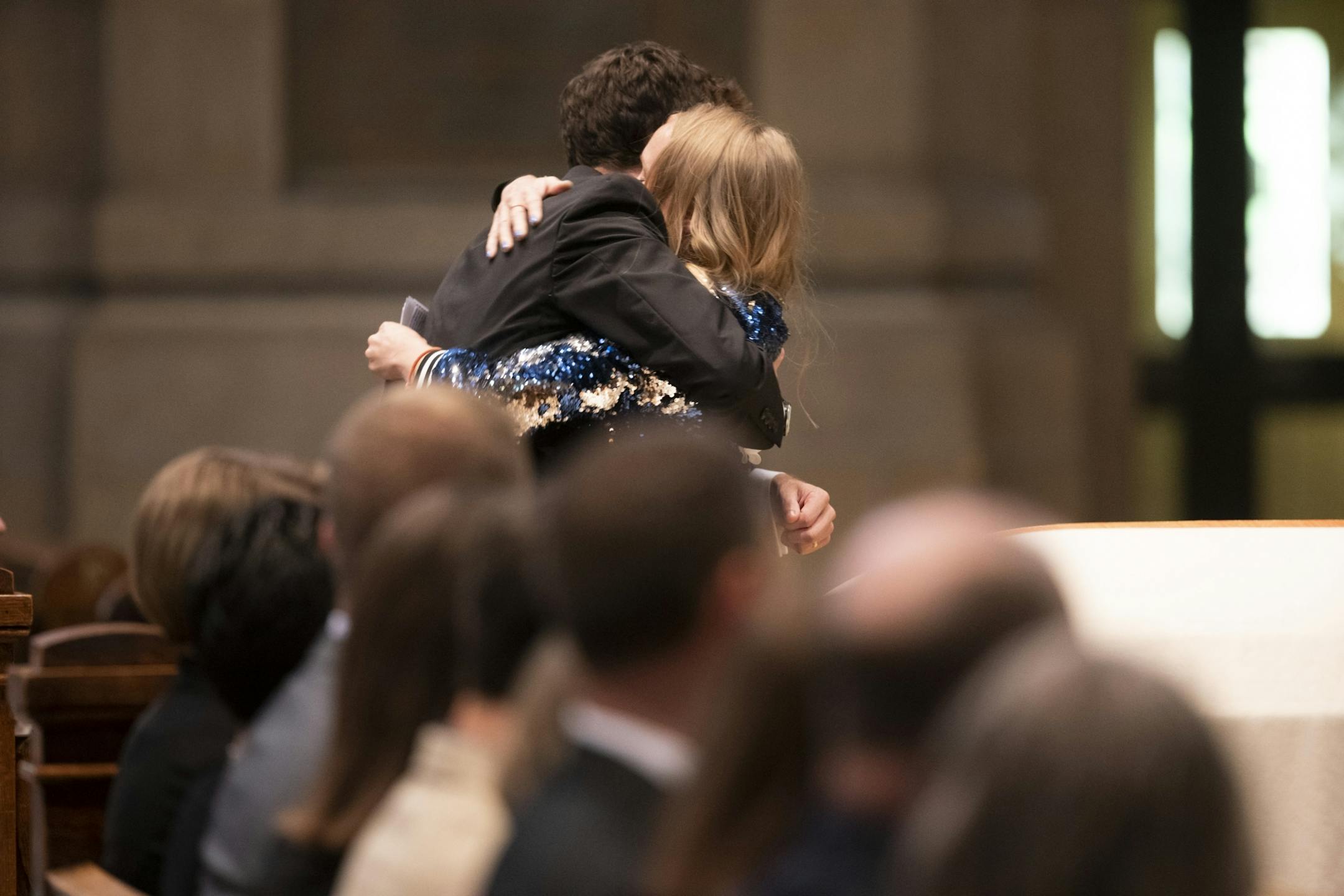 Ladia Albertson-Junkans hugged Gabriele Grunewald's husband, Justin Grunewald, after she gave a remembrance speech wearing a sequin jacket Gabe had worn to a Taylor Swift concert with her at during the funeral at the Basilica of St. Mary in Minneapolis.