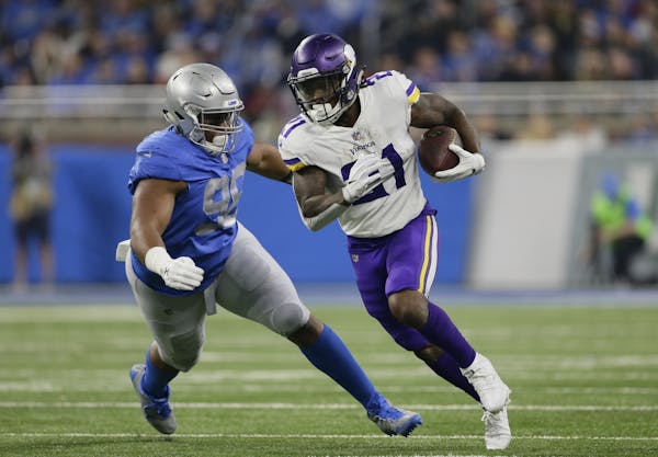 Minnesota Vikings running back Jerick McKinnon (21) is chased by Detroit Lions defensive end Jeremiah Ledbetter (98) during the first half of an NFL f