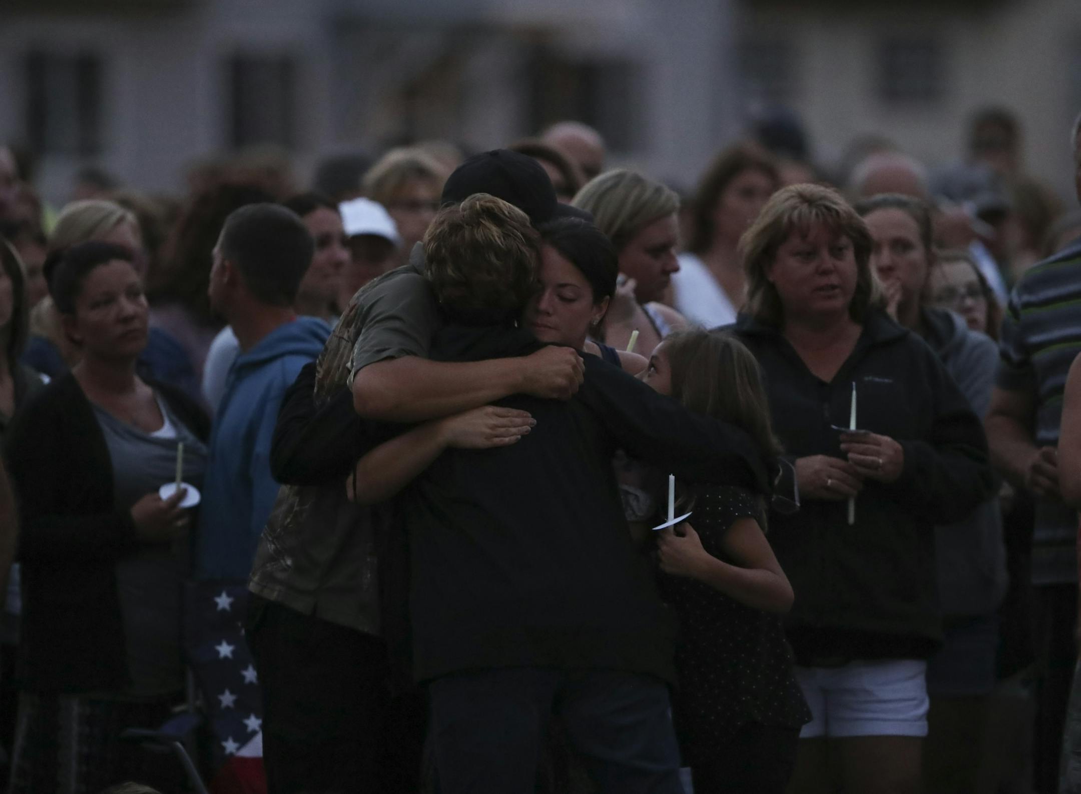 The parents of Alayna Ertl, Matt and Kayla, were hugged by a mourner at the start of the prayer vigil for Alayna Ertl Tuesday night in the parking lot of St. Anthony Church in Watkins.