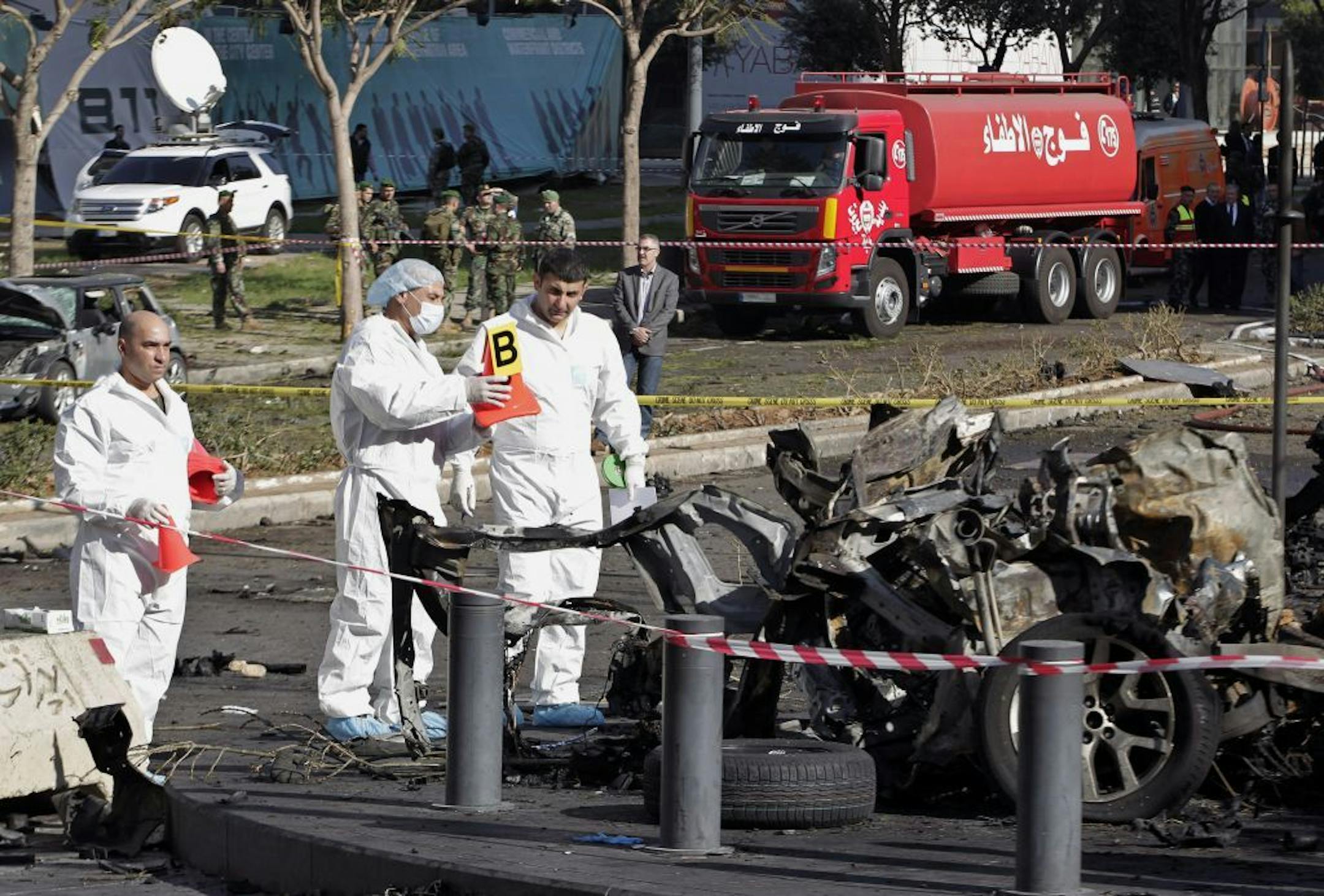 Lebanese army investigators in white coveralls inspect the scene of an explosion in Beirut, Lebanon, Friday, Dec. 27, 2013. A powerful car bomb tore through a business district in the center of the Lebanese capital Friday, killing Mohammed Chatah, a prominent pro-Western politician, and at least five other people in an assassination certain to hike sectarian tensions already soaring because of the civil war in neighboring Syria.