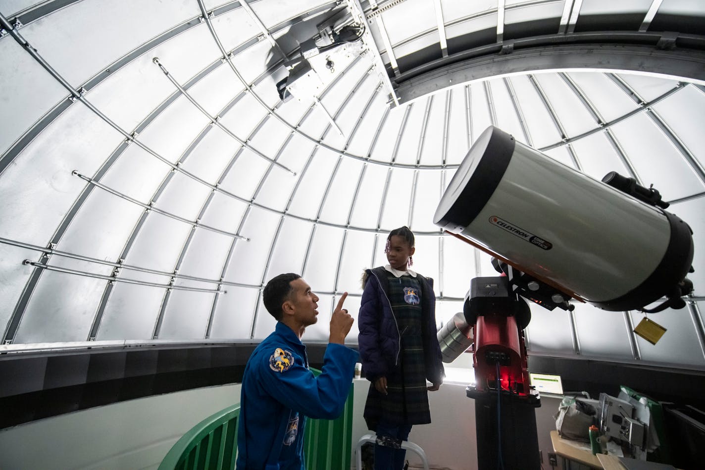 NASA Astronaut Raja Chari told Zyah Drakeford, 10, a view facts about the observatory (that was closed because of rain) as she and others got a chance to view it during a celebration of the launch of the brand-new, world-class observatory at Hall STEM Academy on Wednesday, Nov. 9, 2022 in Minneapolis, Minn. At right is telescope operator Mark Job. ] RENEE JONES SCHNEIDER • renee.jones@startribune.com