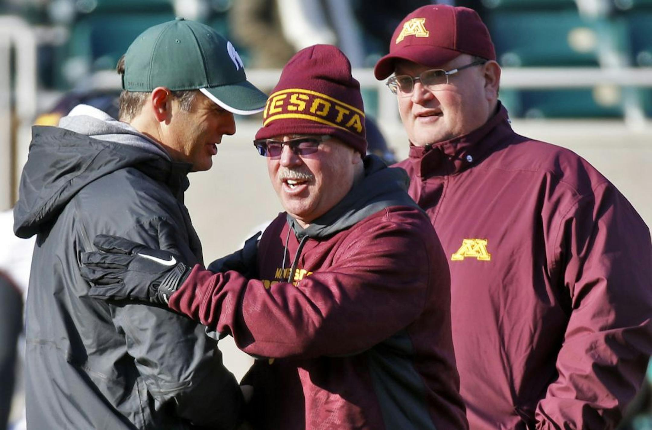 Minnesota Gophers vs. Michigan State Spartans. Minnesota head coach Jerry Kill, center, greeted a Michigan State coach before the start of the game as defensvie coach Tracy Claeys looked on right. (MARLIN LEVISON/STARTRIBUNE