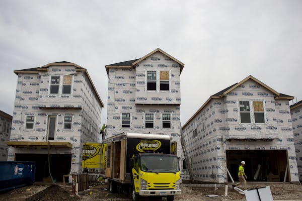 A construction worker walked through a line of homes under construction in the Twin Cities in June.