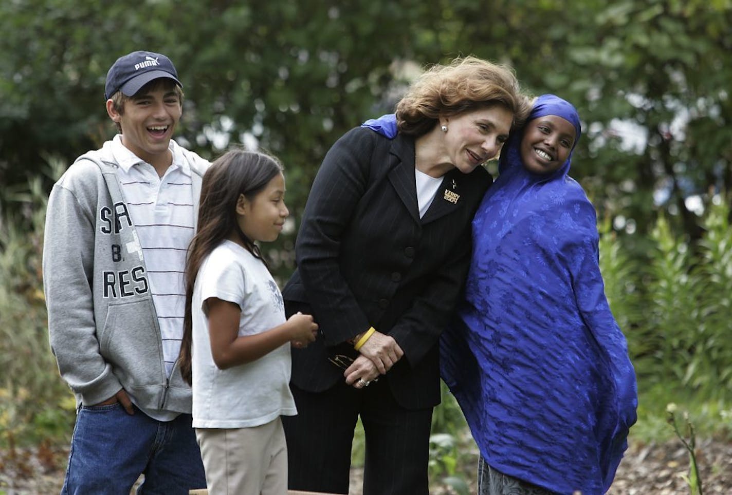 Jerry Holt/Star Tribune St. Paul MN 9/27/2004-----Tyler Berres left 17, Josephine Caballero 9, and Maryan Adani 13 both of Minneapolis posed with Teresa Heinz Kerry for a photo during her visit Monday at youth farm in St. Paul. The Youth Farm and Market Project raise vegetables and sell them at public housing high-rises and neighborhood farmers markets.