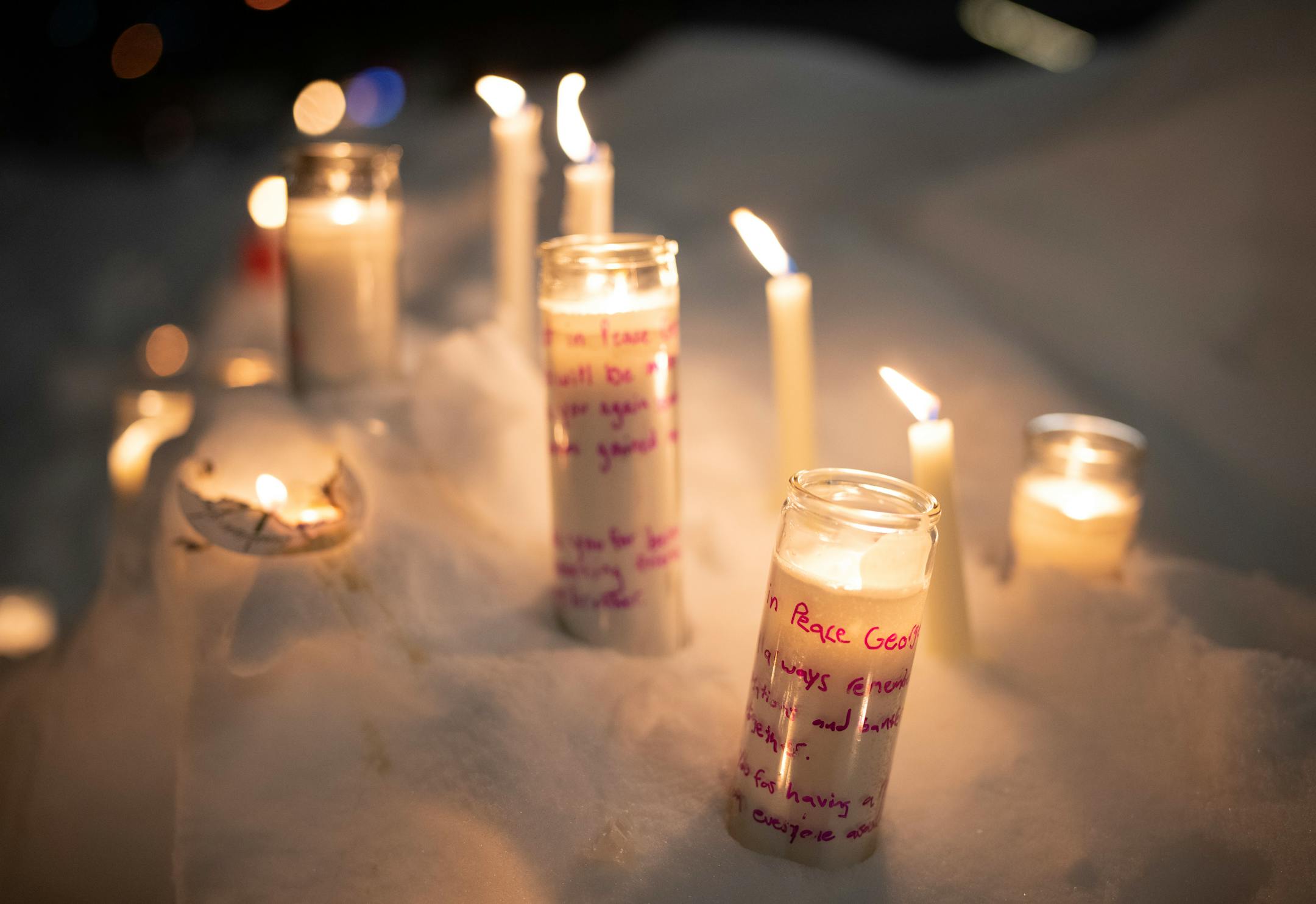 Mourners left candles burning in a snowbank after the vigil.