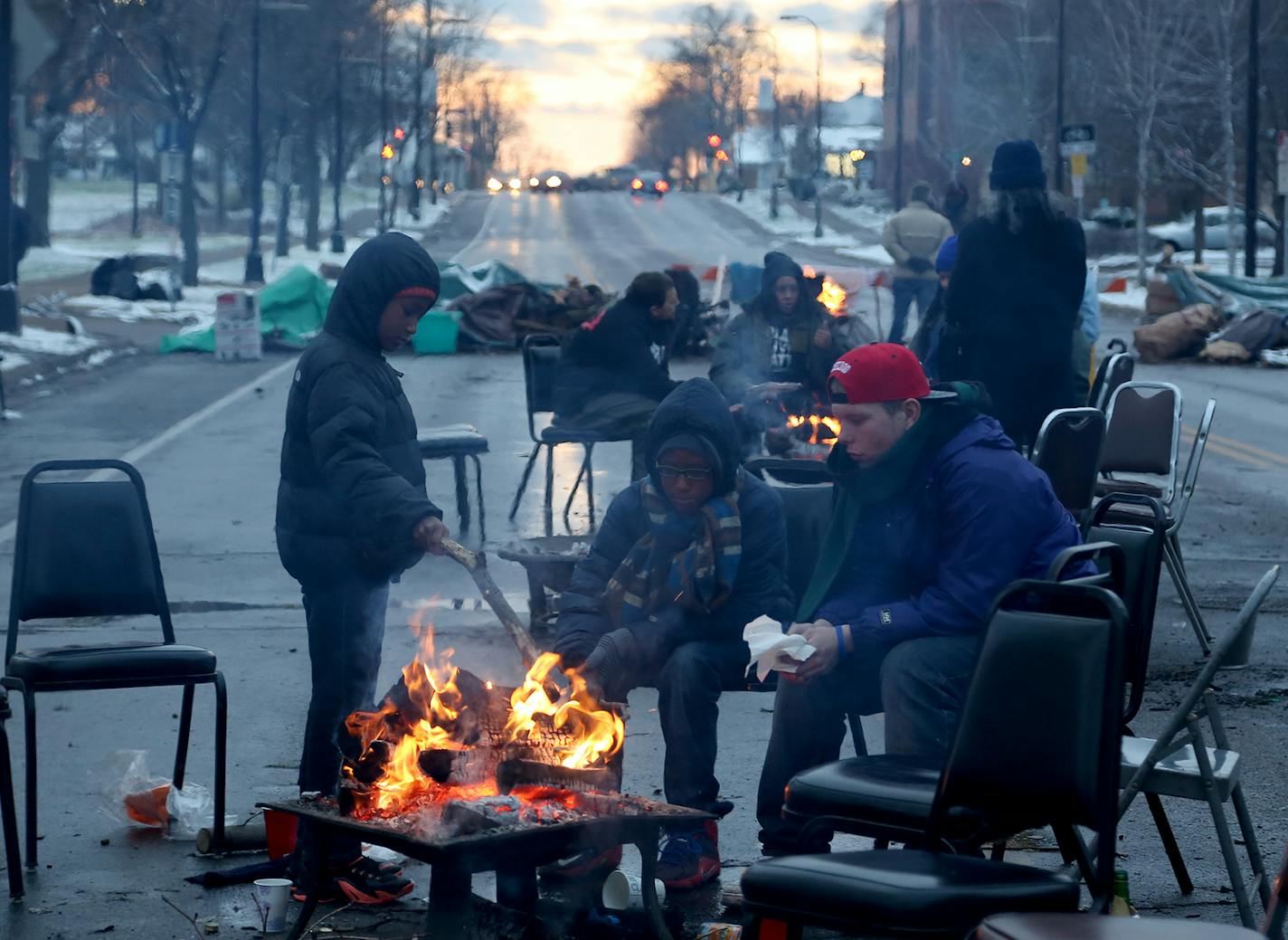 Community members and protesters warmed themselves by the fire during BlackGiving event in front of the Minneapolis Fourth Precinct. ] (KYNDELL HARKNESS/STAR TRIBUNE) kyndell.harkness@startribune.com BlackGiving event on Plymouth Ave in front of the Minneapolis Fourth Precinct in Minneapolis Min., Thursday November 26, 2015.