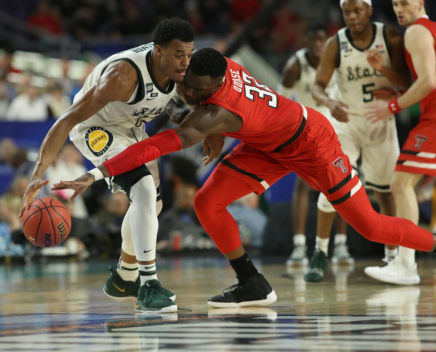 Playing typical Texas Tech defense, center Norense Odiase tried to steal the ball from Michigan State forward Xavier Tillman. in the first half.