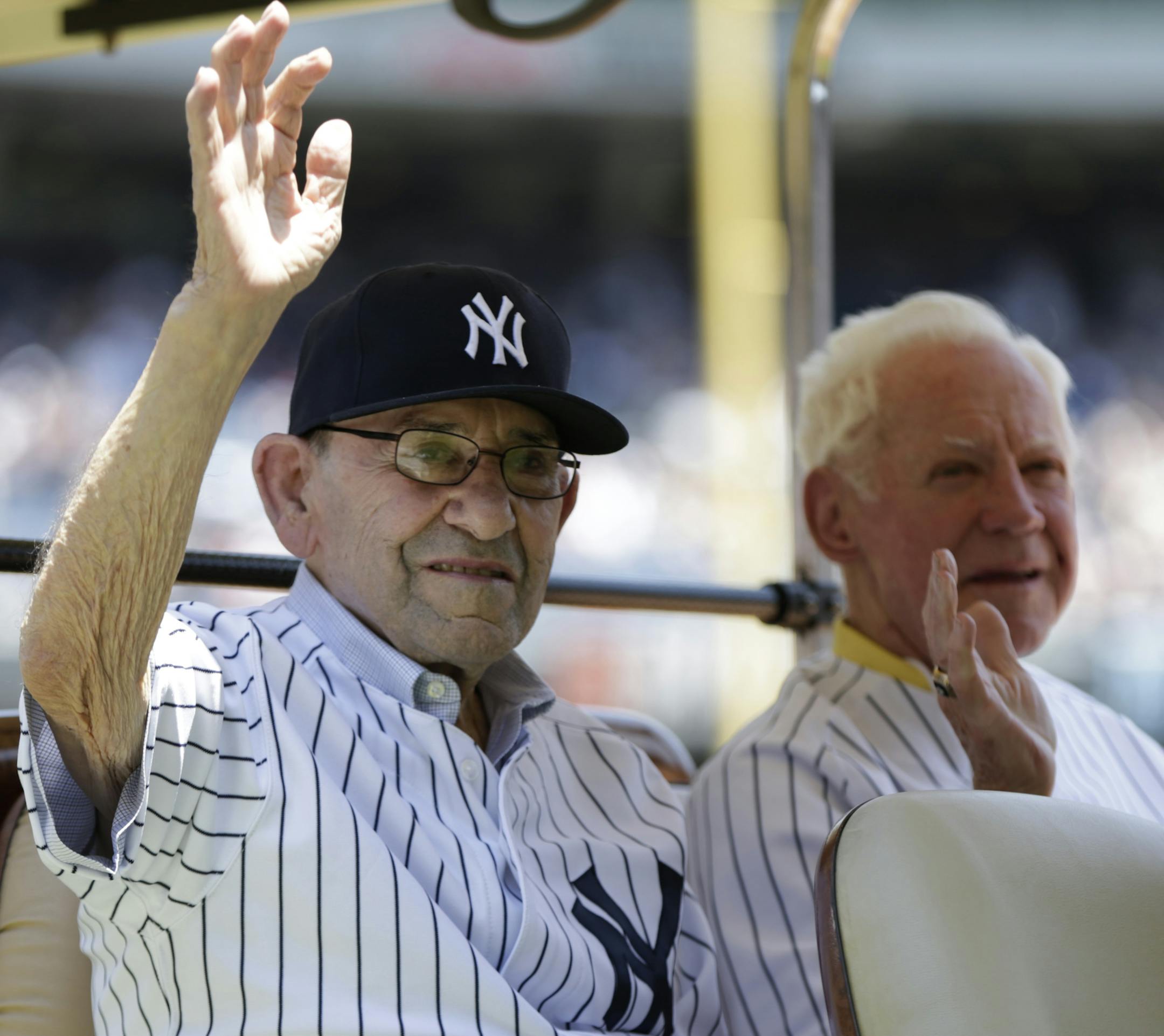 Hall of Famer catcher Yogi Berra, left, and pitcher Whitey Ford ride in the shade of a golf cart before the New York Yankees 67th annual Old Timers Day baseball game Sunday, June 23, 2013, in New York. (AP Photo/Kathy Willens) ORG XMIT: MIN2013071219200186