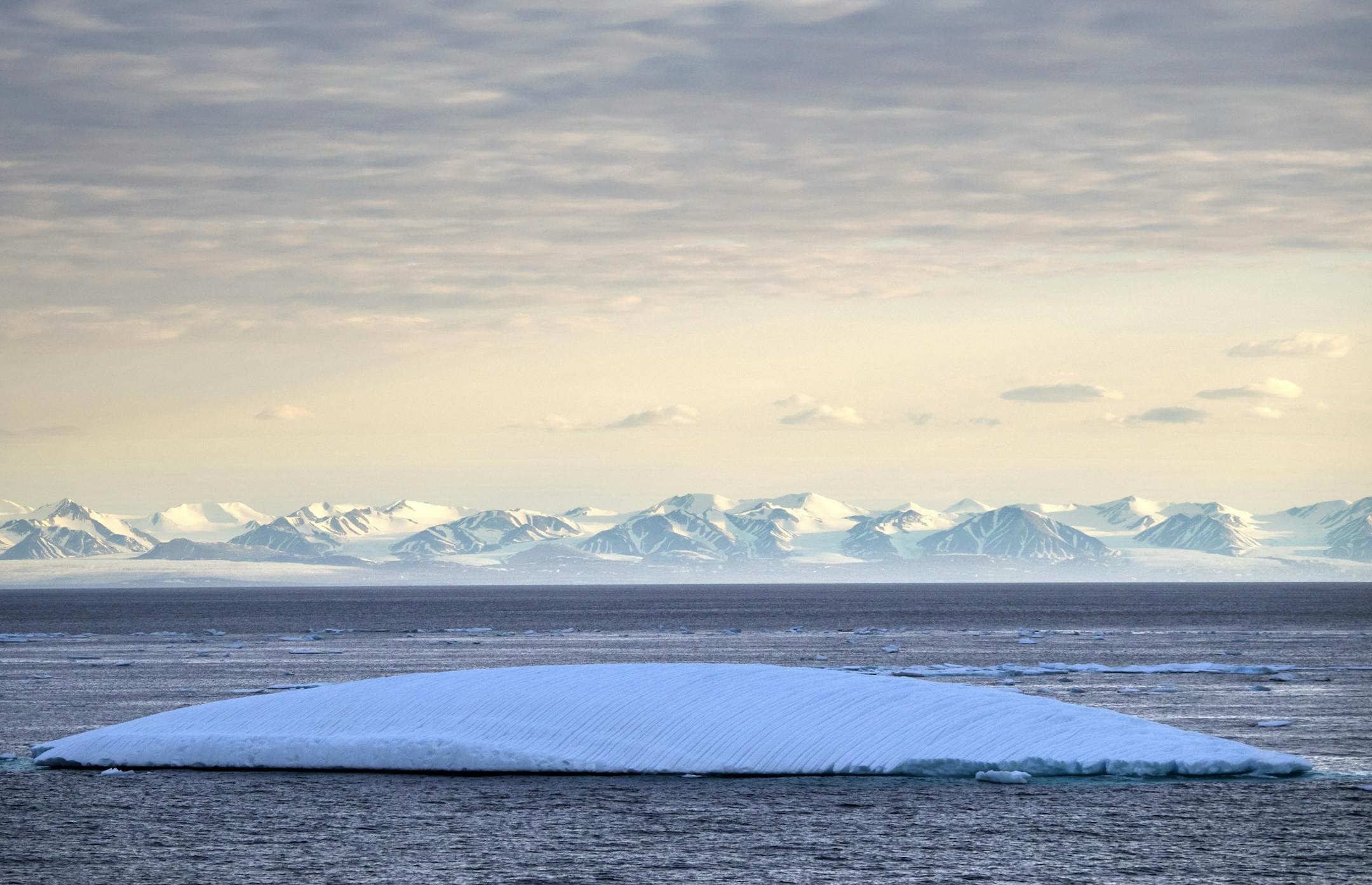 An iceberg floats past Bylot Island in the Canadian Arctic Archipelago, Monday July. 24, 2017. If parts of the planet are becoming like a furnace because of global warming, then the Arctic is best described as the world's air-conditioning unit. The frozen north plays a crucial role in cooling the rest of the planet while reflecting some of the sun's heat back into space. (AP Photo/David Goldman) ORG XMIT: ARC270