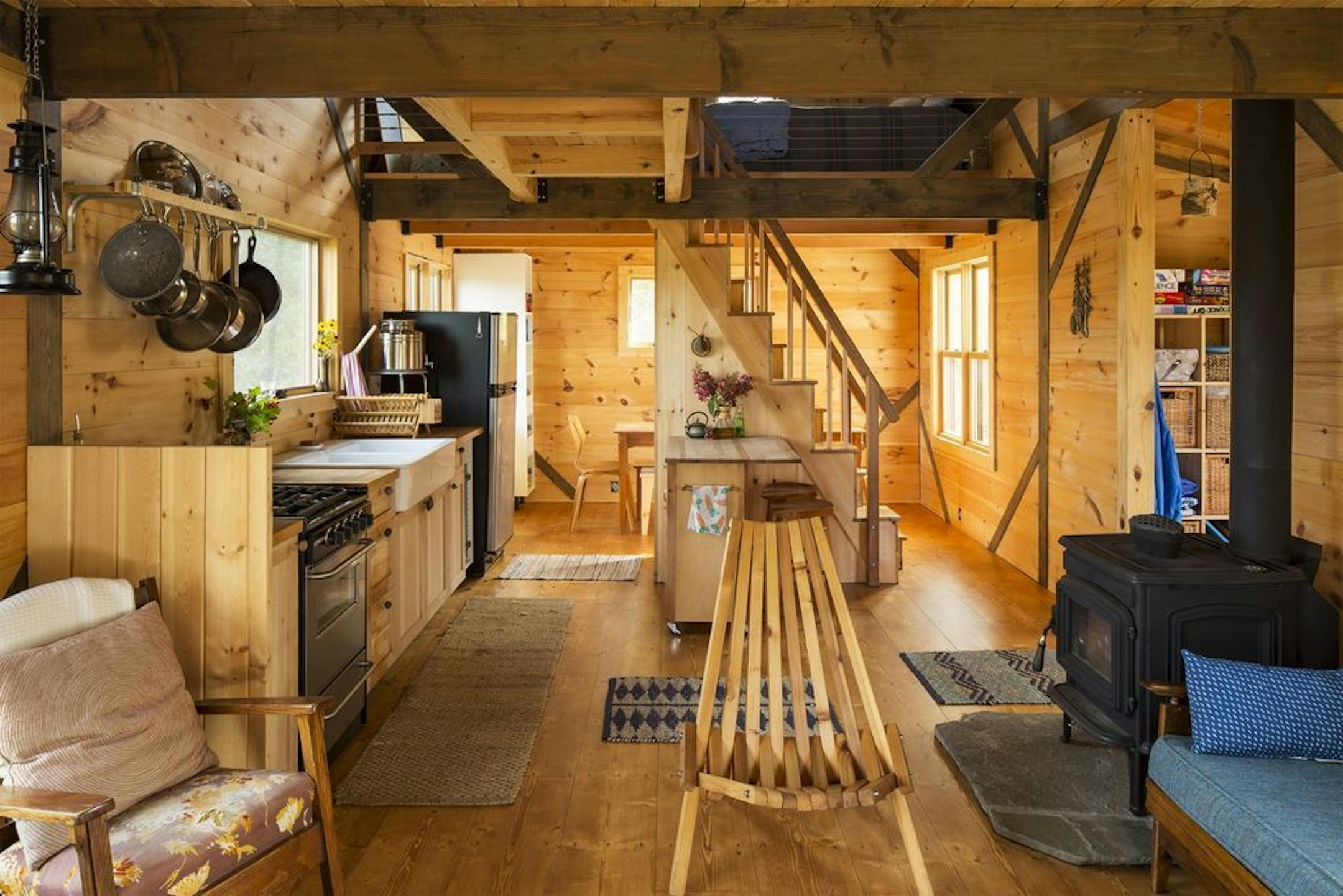 The 600-square-foot off-the-grid timber frame cabin includes a sleeping loft above the living area and a wood burning stove.